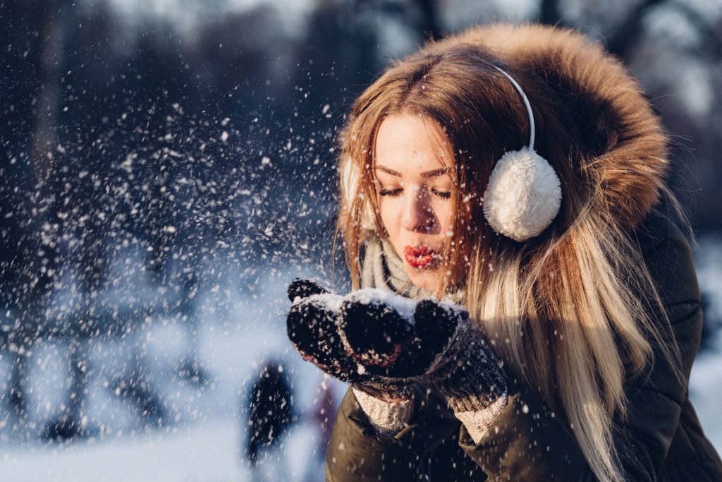 Woman Blowing Snow Off Mitts